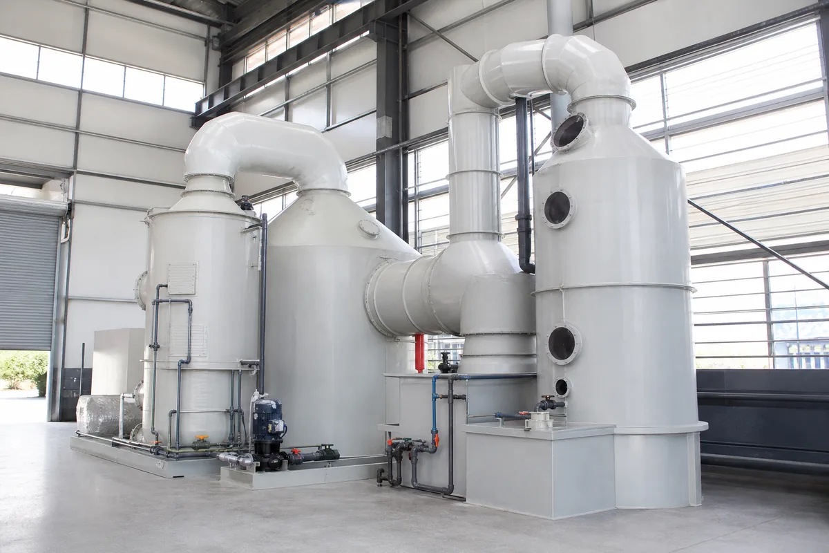 A polypropylene venturi scrubber with pre-scrubbing spray chamber and ductwork, photographed from a low three-quarter front angle in an industrial air-pollution-control installatio